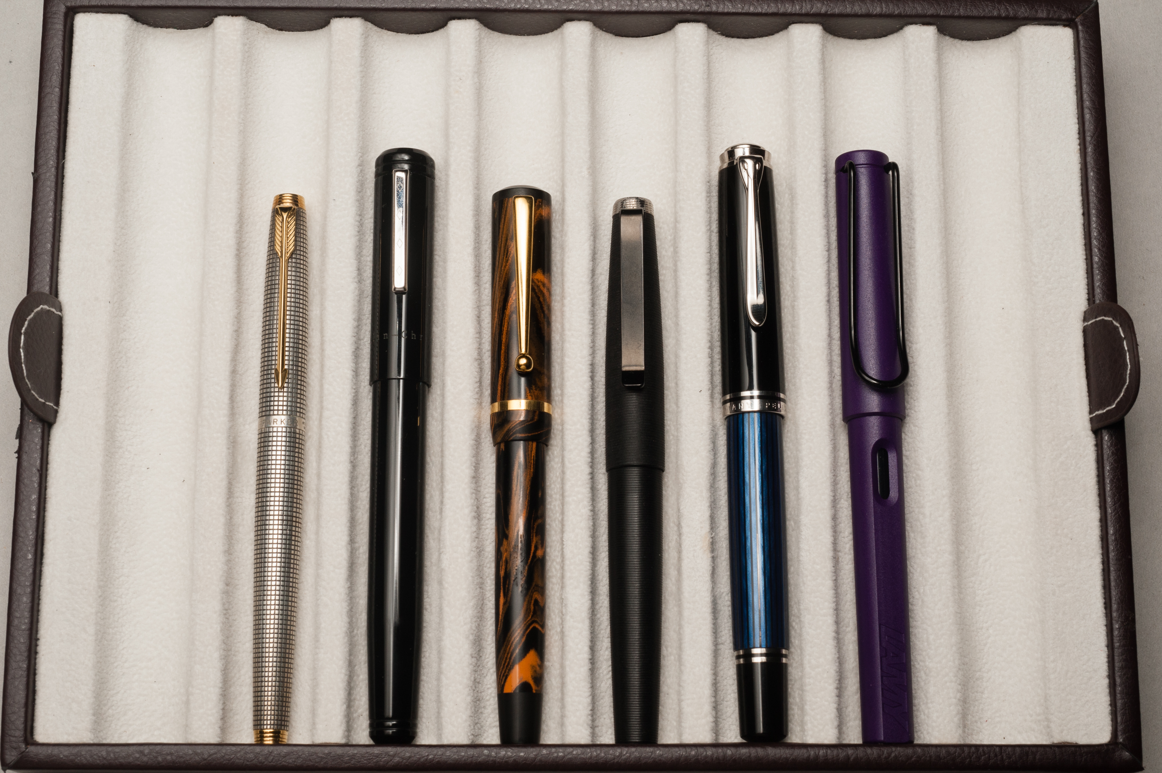 Closed pens from left to right: Parker 75, Franklin-Christoph Model 20, Edison Beaumont, Tactile Turn Gist, Pelikan M805, and Lamy Safari